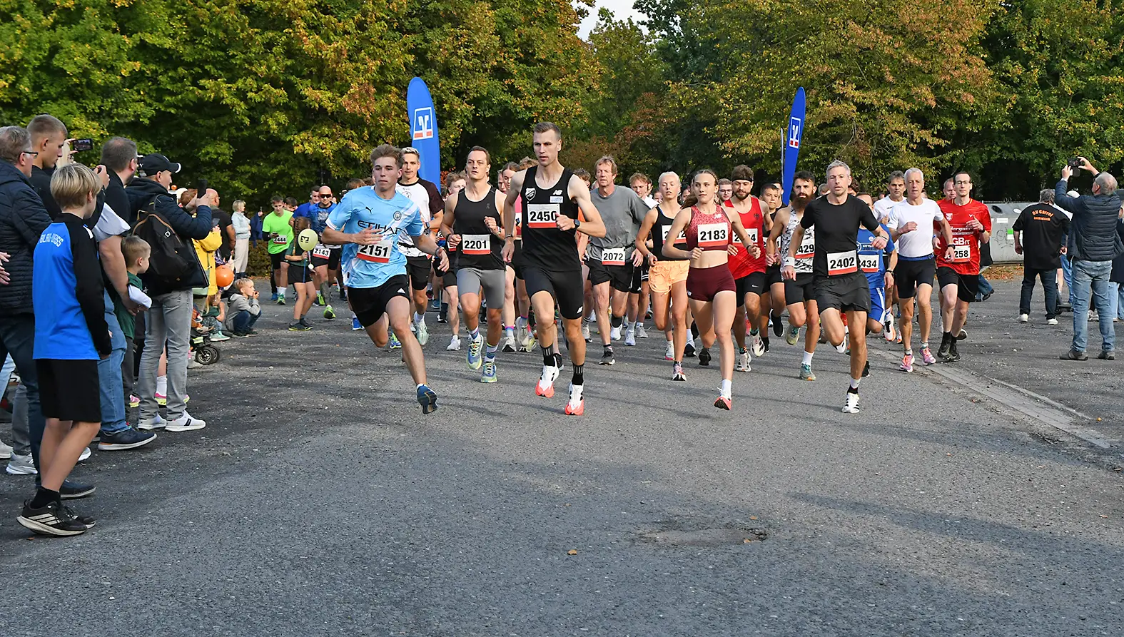 Läuferinnen und Läufer starten beim Citylauf 2025; im Bildhintergrund sind Startbereich und Publikum erkennbar.